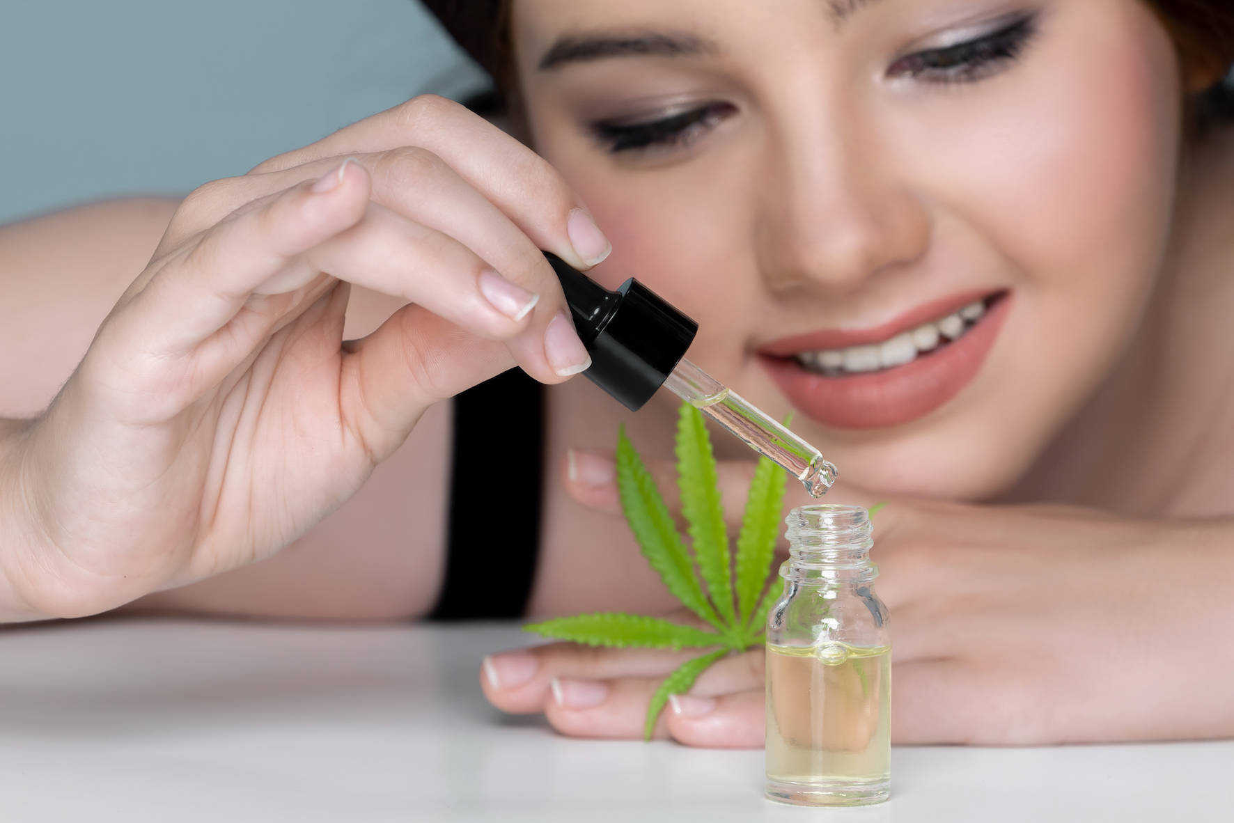 jeune-fille-charmante-appliquant-du-serum-cbd-a-partir-d-huile-extraite-de-cannabis-pour-les-soins-de-la-peau.jpg